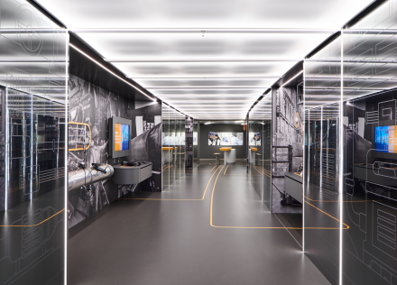 Ausstellungsfläche mit weißen Regalen und interaktiven Displays